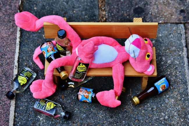 Ein Kuscheltier liegt zwischen kleinen Schnappsfläschchen auf der Straße