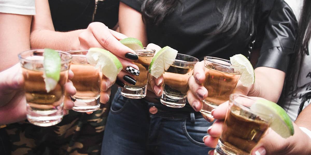 Take It Serious Spiele lassen sich auch als Trinkspiel nutzen. Freunde haben Shots in der Hand und stoßen damit an.