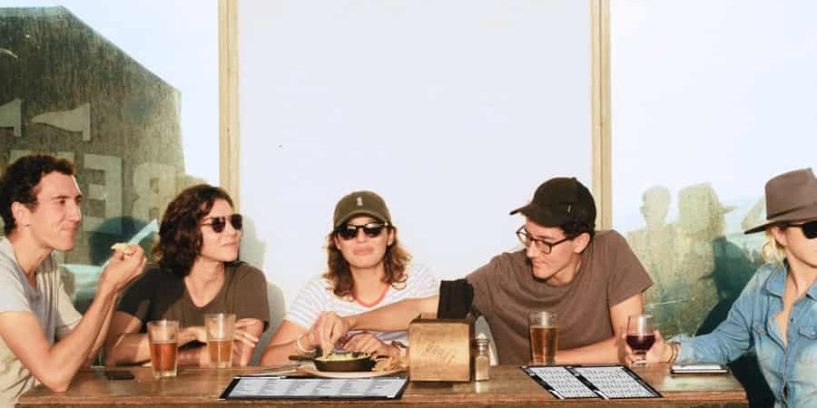 Freunde sitzen in der Abendsonne und spielen das Partyspiel Stadt Land Unseriös