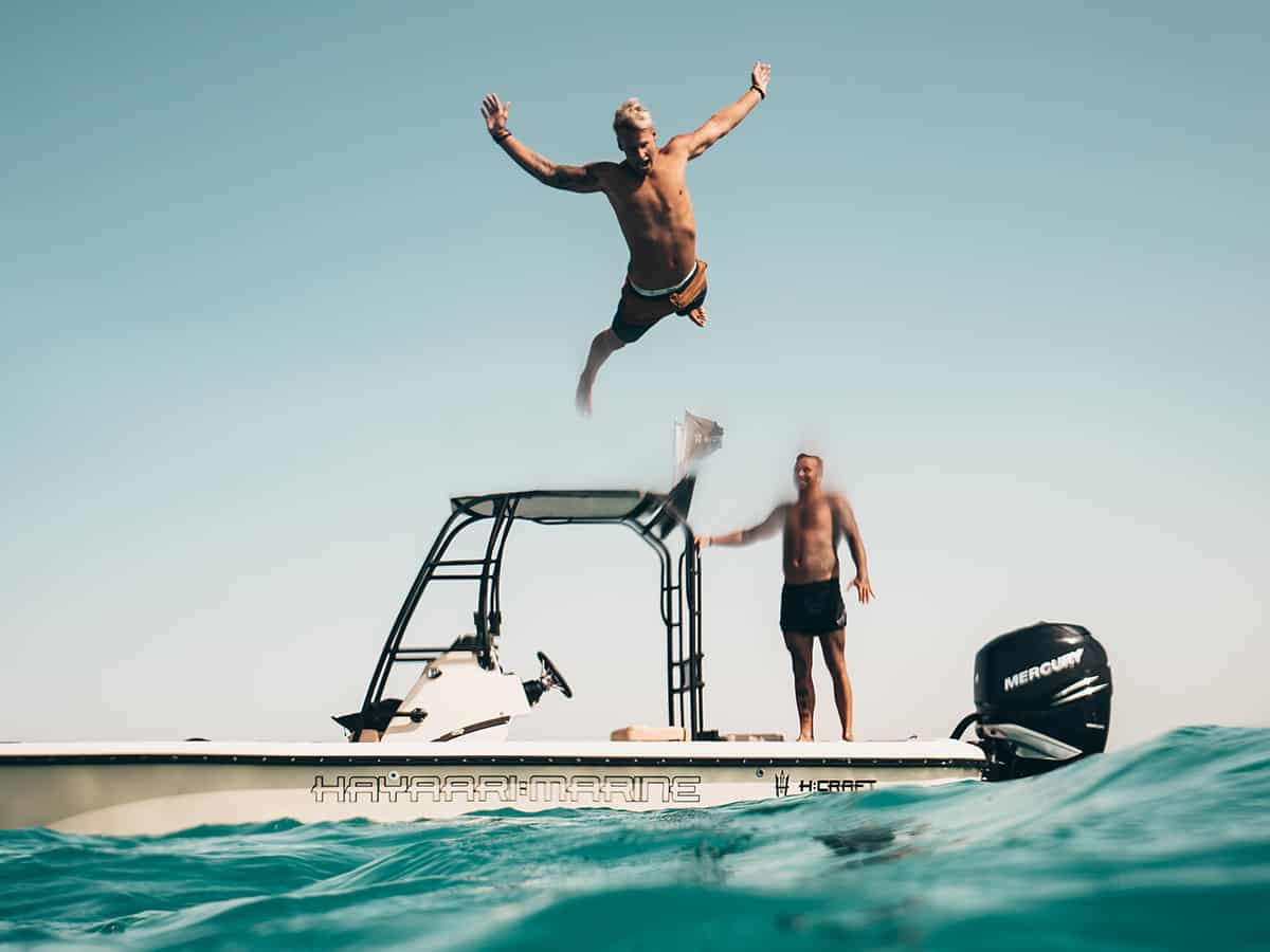 Freund springen von einem Boot ins Wasser. Das ist Sommerurlaub!